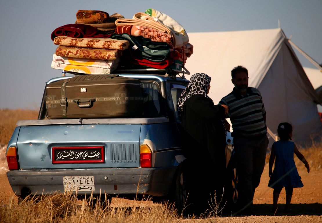 Displaced Syrians wait in a makeshift camp to cross the Jordanian border on July 1, 2018.