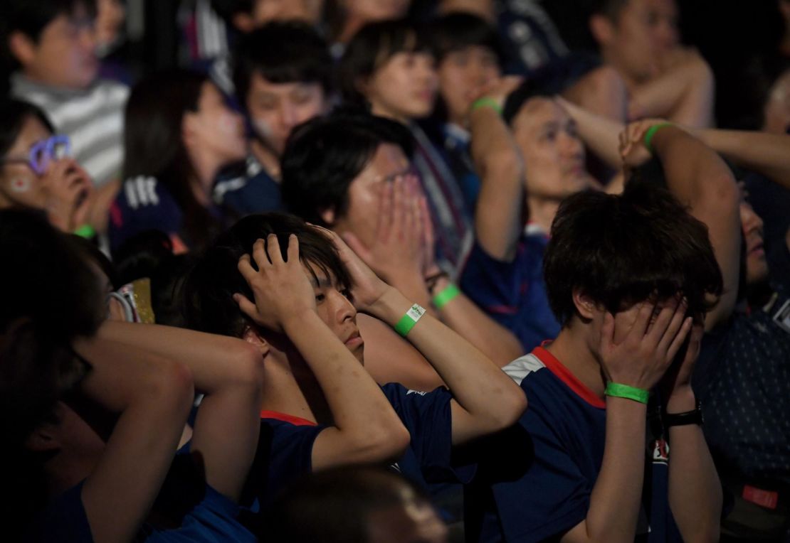 Football fans in Tokyo react to watching Japan's loss to Belgium in a public viewing of the 2018 Russia World Cup.