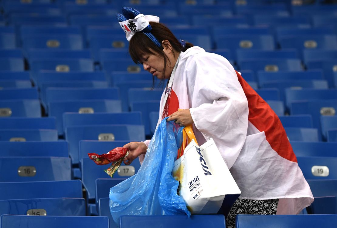 Japan fans collect rubbish from the stands following their sides defeat in the 2018 FIFA World Cup Russia Round of 16 match between Belgium and Japan