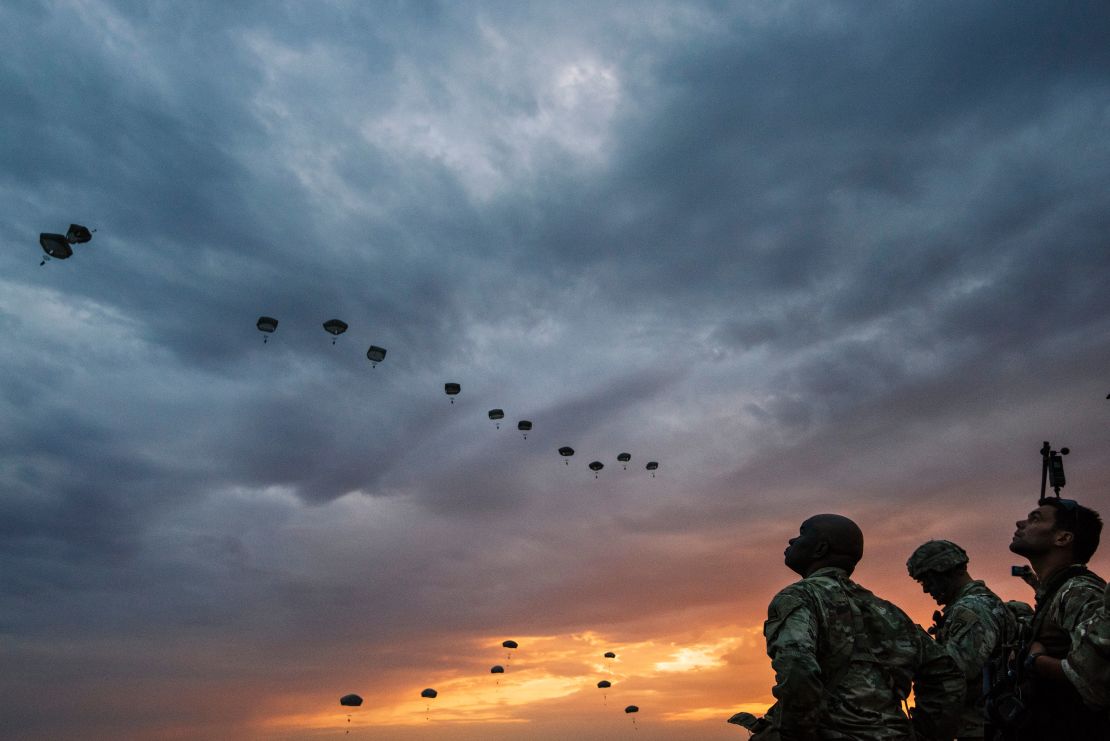 US Army soldiers look on while NATO paratroopers drop out of a US Air Force Hercules during the 'Swift Response 17' joint airborn military exercise at Bezmer airfield near the village of Bezmer on July 18, 2017.