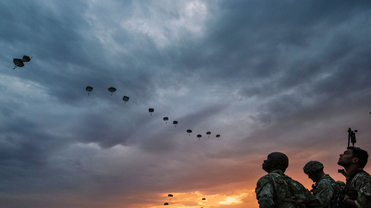 US Army soldiers look on while NATO paratroopers drop out of a US Air Force Hercules during the 'Swift Response 17' joint airborn military exercise at Bezmer airfield near the village of Bezmer on July 18, 2017.