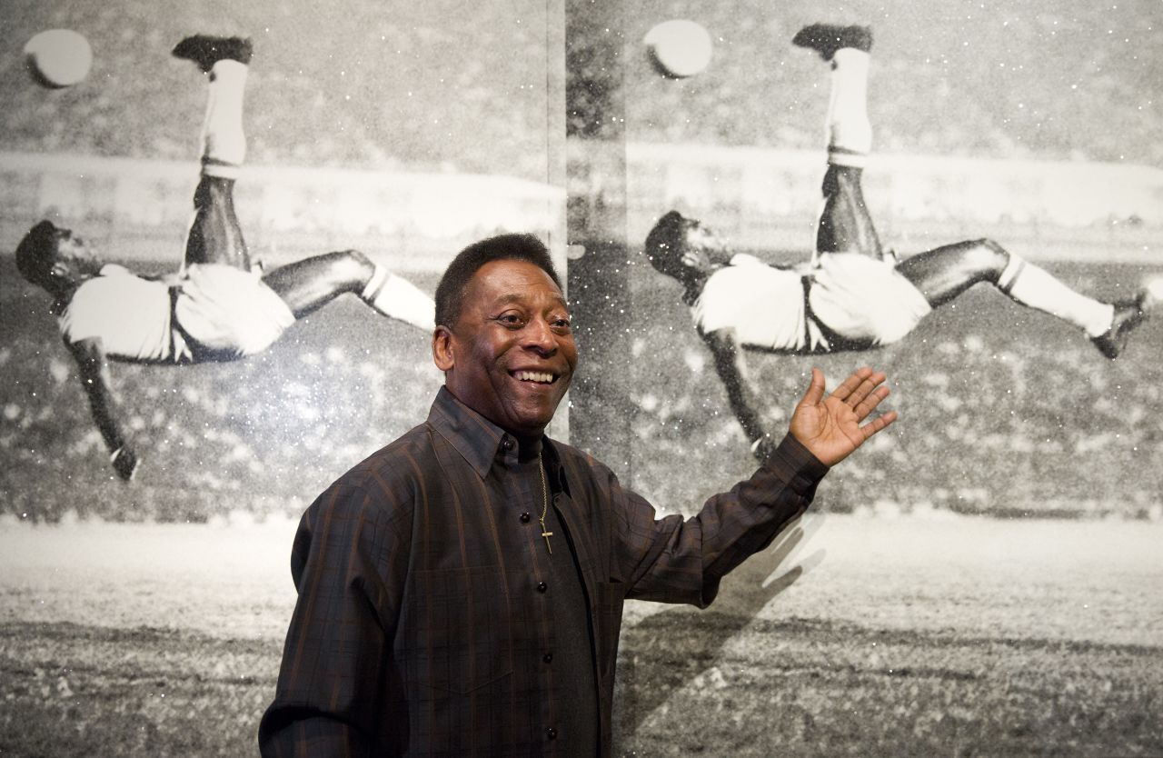 Brazilian football legend Pelé poses in front of "Pelé, Bicycle Kick" by artist Russell Young at London's Halcyon Gallery in 2015.