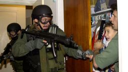 In this third of seven sequential photos, Elian Gonzalez is held in a closet by Donato Dalrymple, one of the two men who rescued the boy from the ocean, right, as government officials search the home of Lazaro Gonzalez for the young boy, early Saturday morning, April 22, 2000, in Miami. Armed federal agents seized Elian Gonzalez from the home of his Miami relatives before dawn Saturday, firing tear gas into an angry crowd as they left the scene with the weeping 6-year-old boy. Alan Diaz/AP