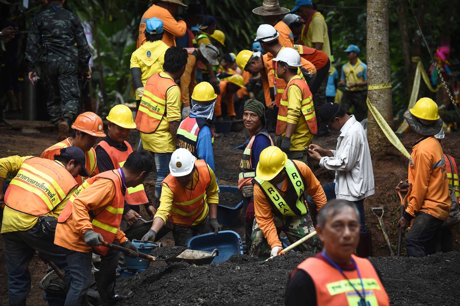 Workers fix the road leading to the cave on July 3.