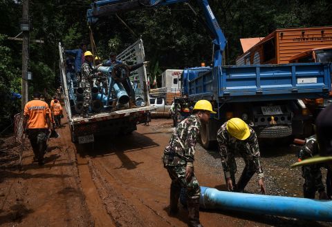 Technicians lift water pumps to the drilling site on July 1.
