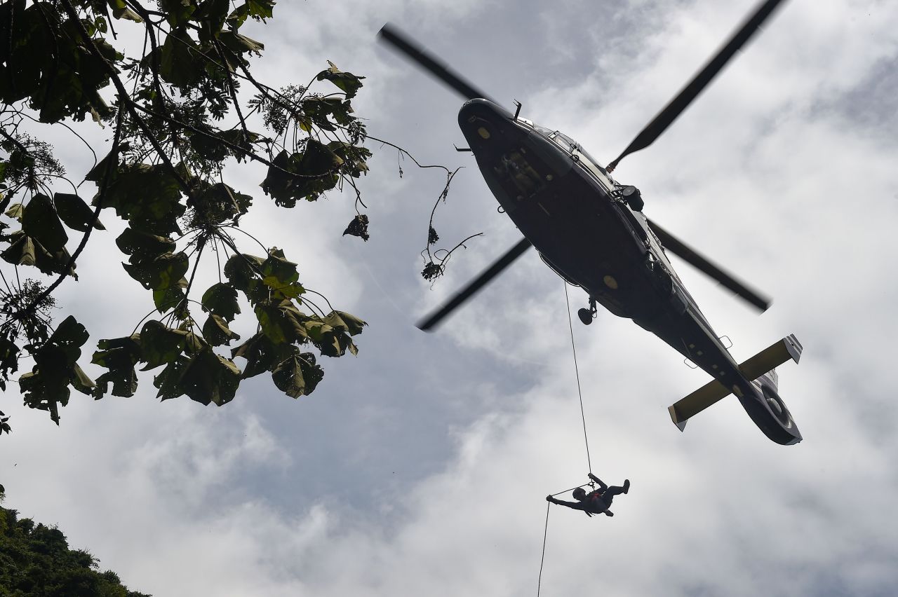 A Thai Air Force worker drops near a possible cave opening on June 30.