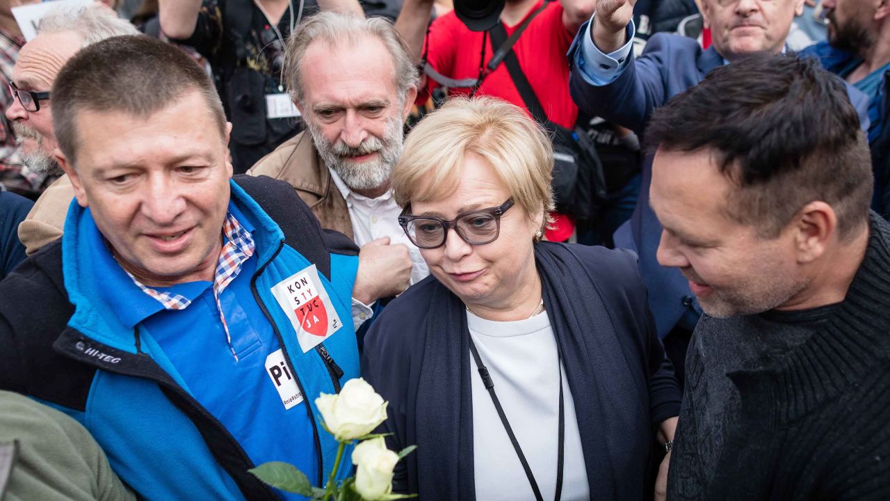 Polish Supreme Court Justice president Malgorzata Gersdorf, center, arrives for work Wednesday at the Supreme Court building in Warsaw as people gather to support her.