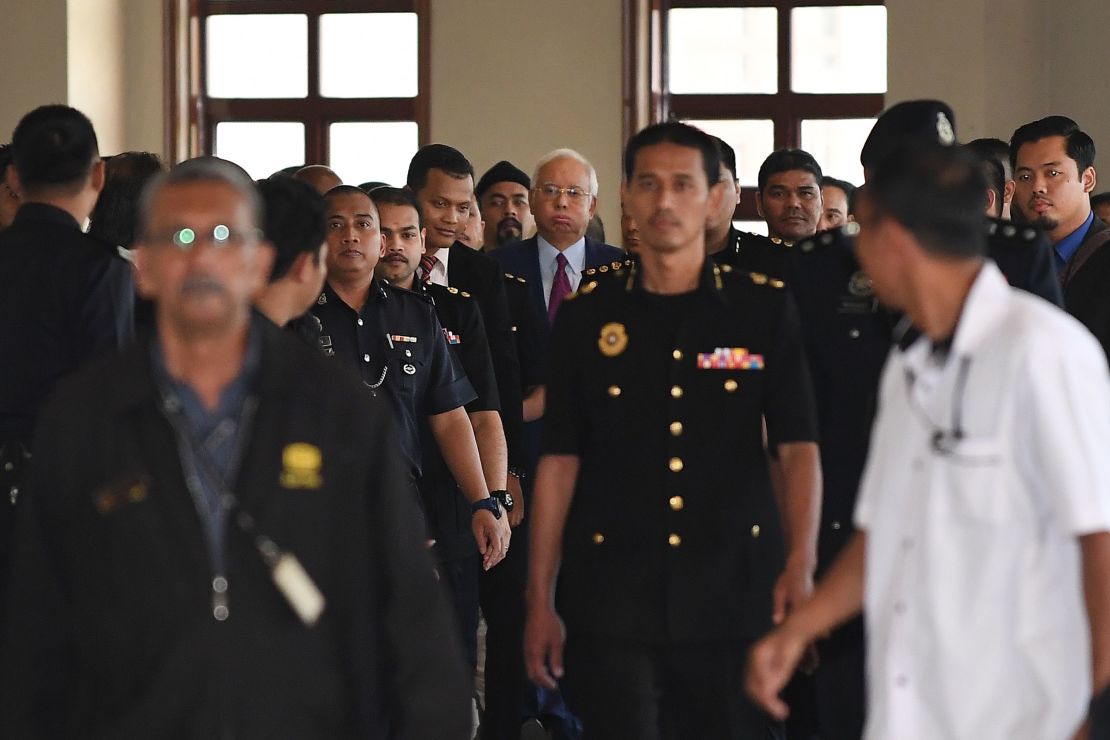 Former Malaysian prime minister Najib Razak (center, in the blue shirt) is transferred to a high court.