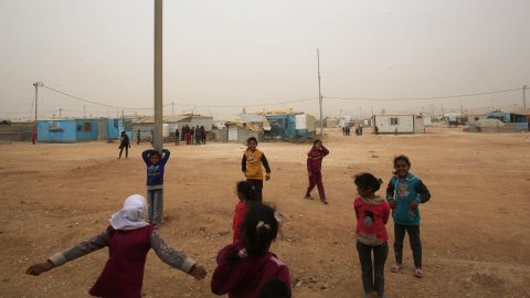 Syrian refugee children play during a sand storm at the Zaatari refugee camp on November 13, 2017. 
Some 80,000 Syrian refugees living in the Zaatari camp will have access to 14 hours of electricity per day instead of eight hours, thanks to the opening of the new solar power station. / AFP PHOTO / KHALIL MAZRAAWI        (Photo credit should read KHALIL MAZRAAWI/AFP/Getty Images)
