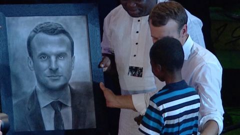 11-year old Nigerian hyperrealist artist, Kareem Olamilekan draws portrait of French President's Macron at the African shrine on July 3, 2018.