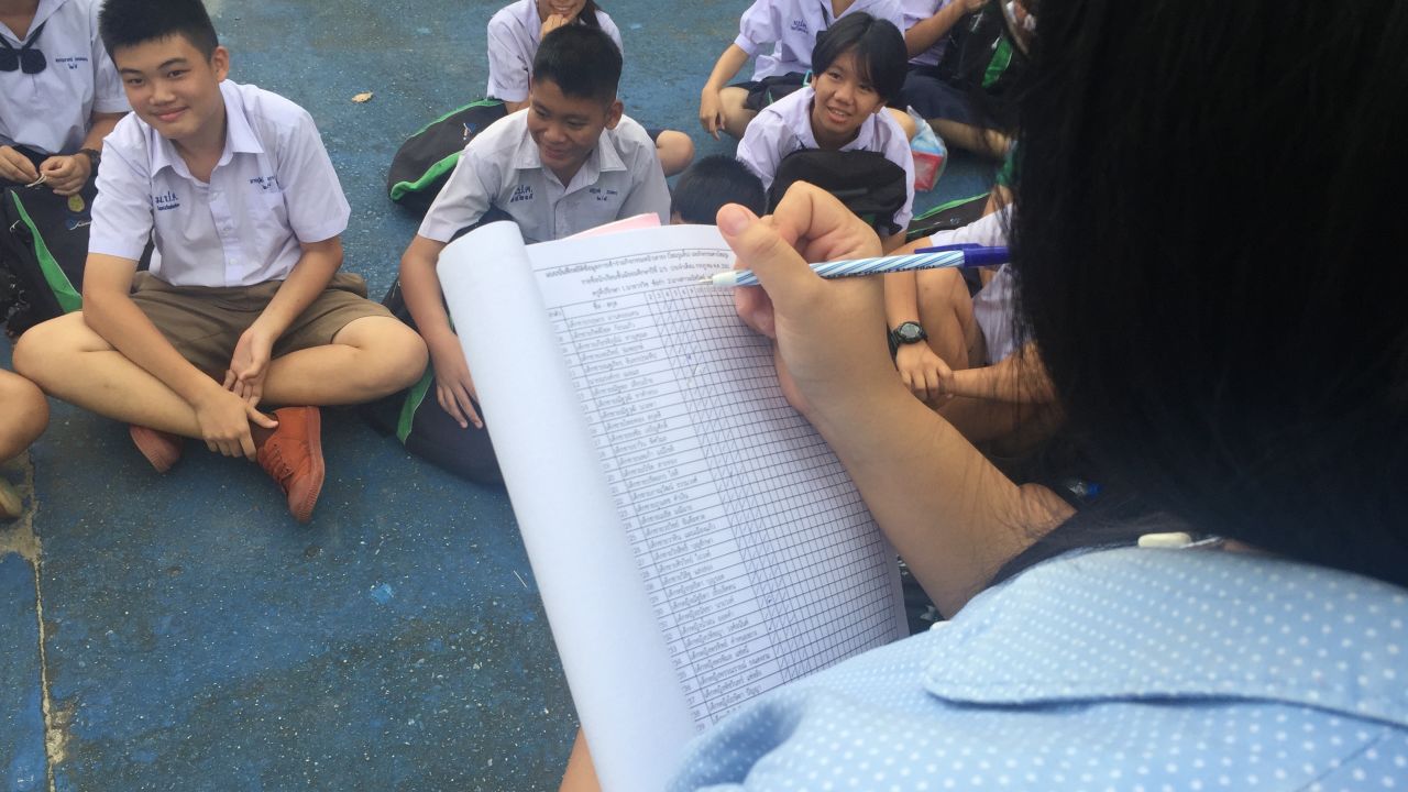 Teacher Manutsanit Jongpunyanon reads the register each morning. The name Nuttawut Takumsai is left blank.