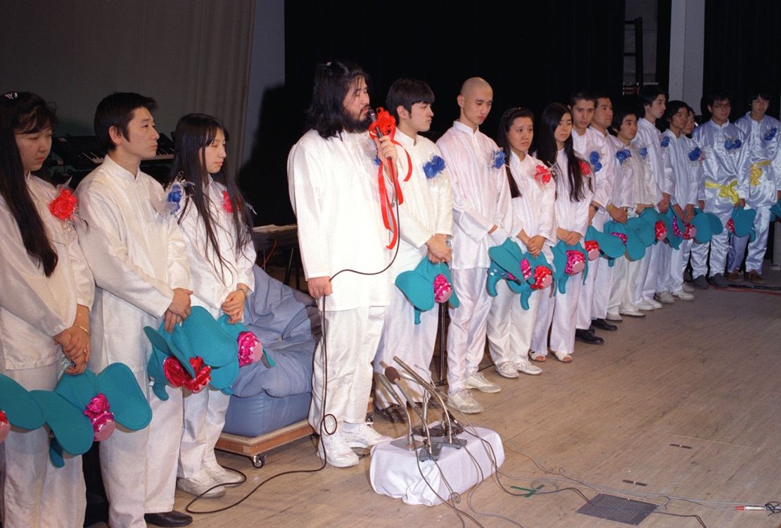 Aum Shinrikyo cult members, alongside group founder Shoko Asahara (4th from L), speak at a press conference in Tokyo to announce a plan to field candidates for the general election in this photo taken in January 1990.