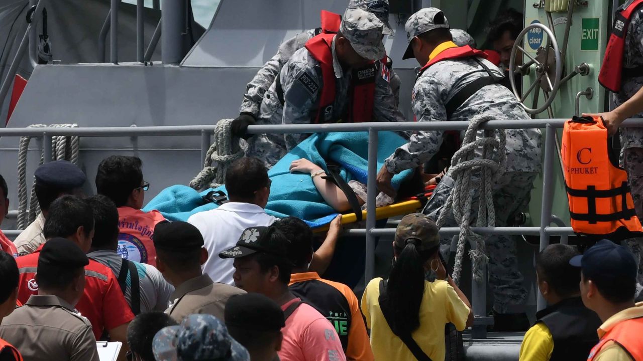 Rescue personnel carry an injured passenger on a stretcher.