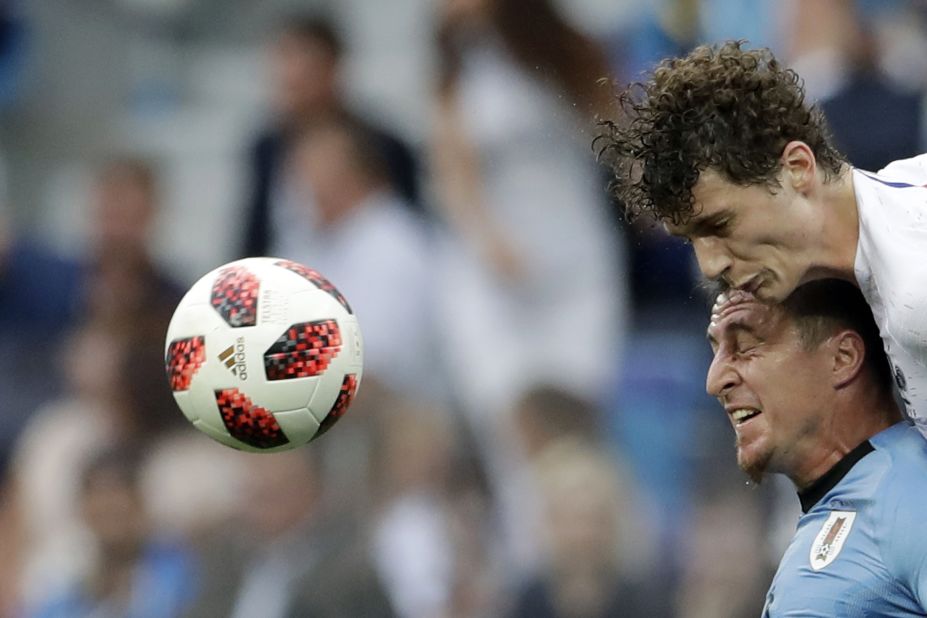 France's Benjamin Pavard, top, and Uruguay's Cristian Rodriguez compete for a header.