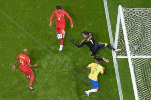 Belgian goalkeeper Thibaut Courtois leaps for a loose ball in the box.