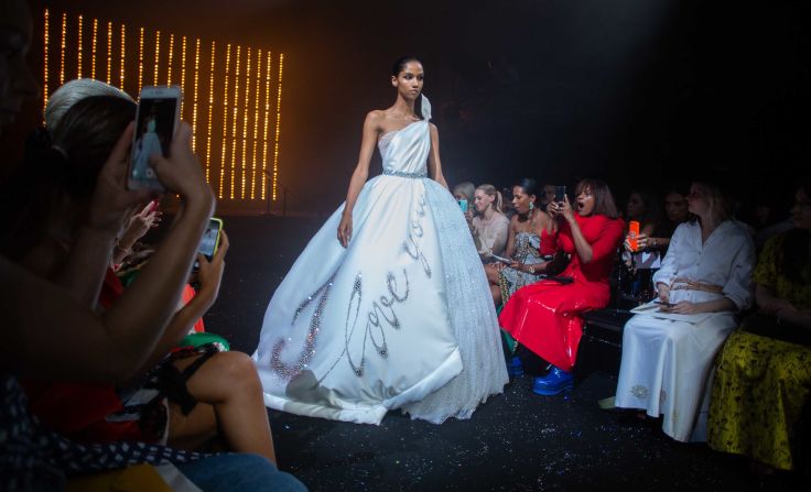 A woman on the front row reacts as a model takes the runway. 