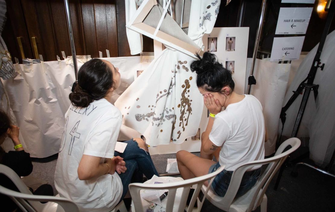 Tailors take a break while putting the finishing touches on a creation backstage.