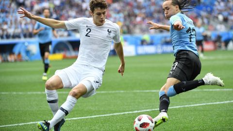 France defender Benjamin Pavard (L) vies for the ball with Uruguay defender Diego Laxalt in the World Cup. Pavard will join Bayern at the end of the season along with Hernandez.