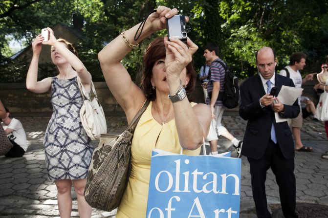 Pedestrians take pictures of a male peacock that escaped from the Central Park Zoo as it perched on a window ledge in 2011.