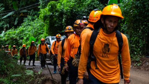 Men from the Department of Disaster Prevention and Mitigation arrive to the cave entrance on July 6, in Chiang Rai, Thailand. 