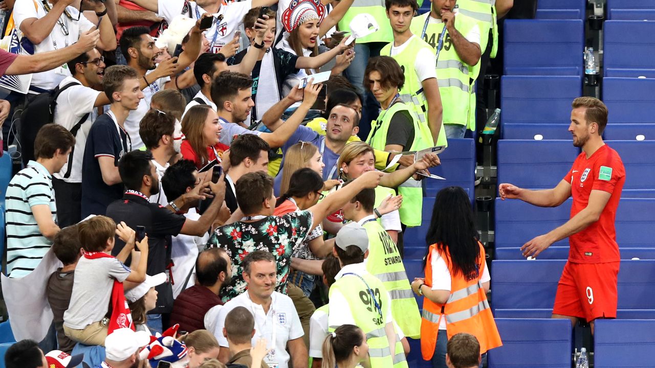 Kane signs autographs for fans in the stands following victory over Sweden