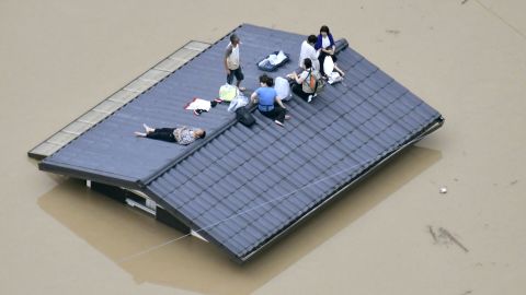 People wait to be rescued on the roof of a house in Kurashiki, Okayama prefecture.