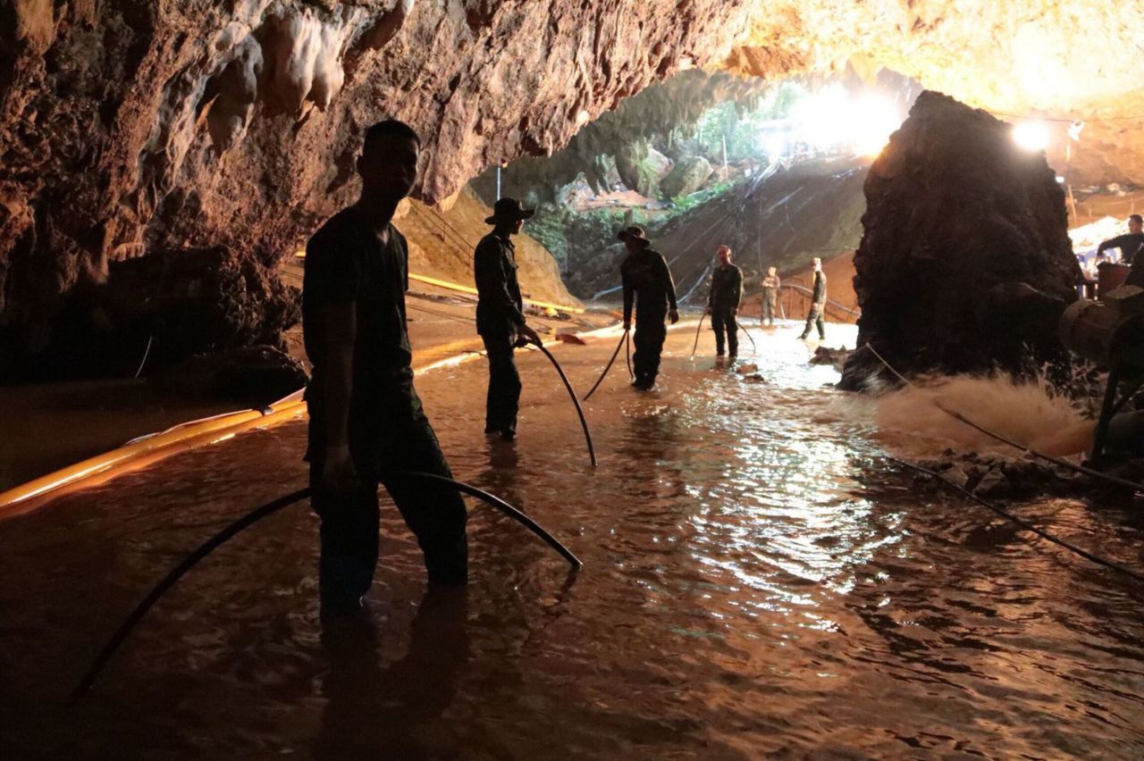 Rescue teams arrange a water-pumping system at the cave's entrance on July 7.