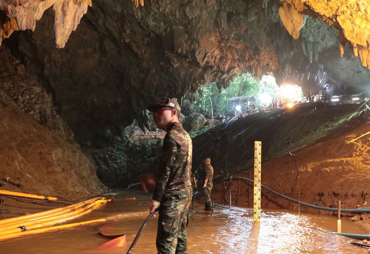Military personnel work inside a cave.