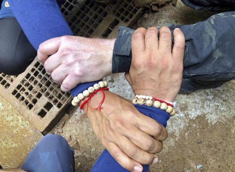This undated photo, released via the Thailand Navy SEAL Facebook page, shows rescuers with their hands locked. The caption said, "We Thai and the international teams join forces to bring the young Wild Boars home." The Wild Boars is the name of the soccer team the boys play on.