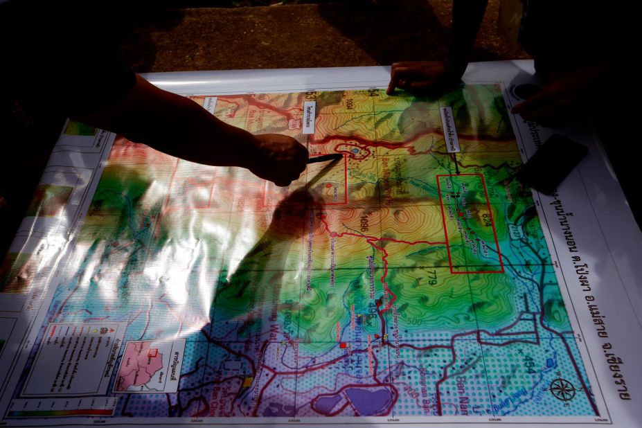Thai forest rangers examine a map as they review their rescue options on July 8.