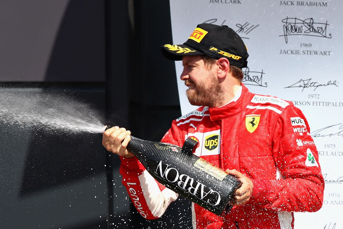 Race winner Sebastian Vettel of Germany and Ferrari celebrates on the podium after winning the British Grand Prix at Silverstone.