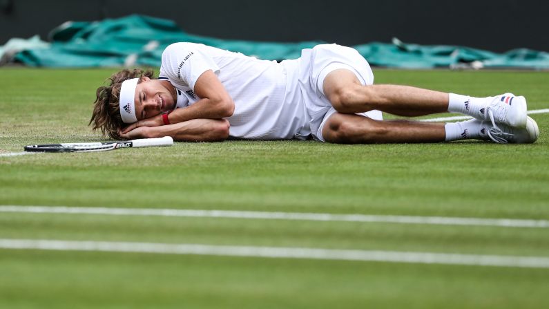 Alexander Zverev pretends to take a nap after falling on the court during the men's singles second round match against Taylor Fritz at the Wimbledon Championships in London, on Thursday, July 5. 
