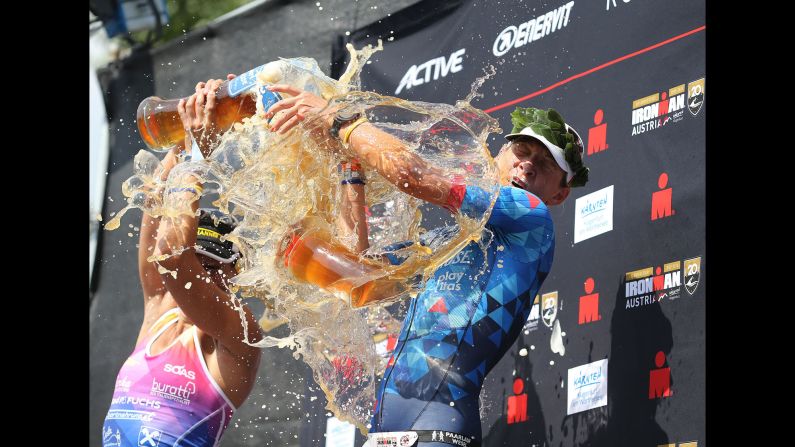 Mareen Hufe, right, celebrates on the podium after winning the women's race at Ironman Austria-Karnten triathlon on Sunday, July 1, in Klagenfurt, Austria. 