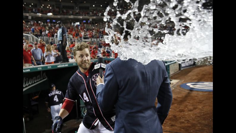 Washington Nationals' Mark Reynolds, left, dodges water with the help of MASN's Dan Kolko, who took the brunt of it, after a baseball game against the Miami Marlins on Friday, July 6, in Washington. 