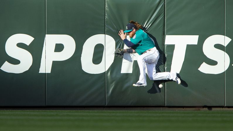 Ben Gamel of the Seattle Mariners runs into the center field wall while trying to catch an RBI triple by Tony Wolters of the Colorado Rockies in the second inning on Friday, July 6, in Seattle.