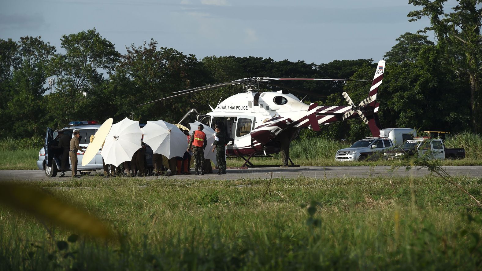 Thai police and military officers use umbrellas to shield a rescued boy before he was transported to a hospital on July 9.