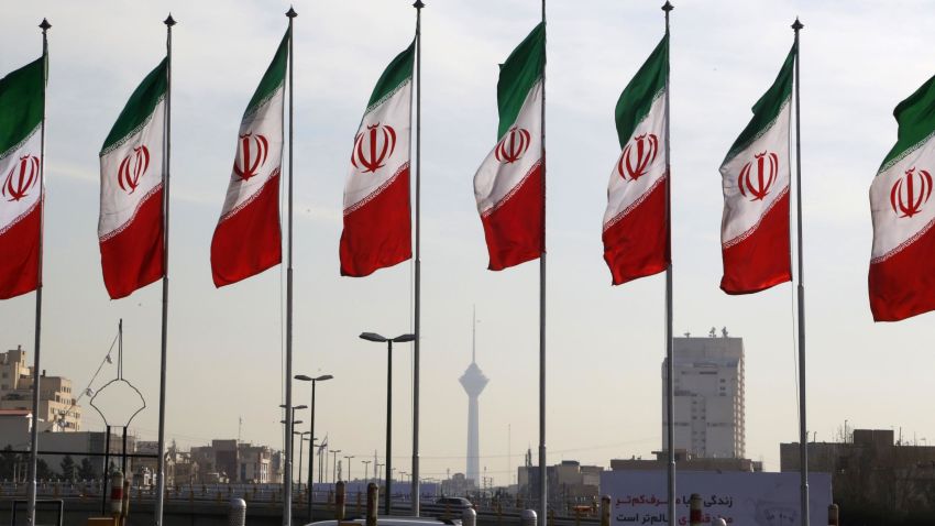 Tehran's landmark Milad Tower is seen through a row of national flags in the center of the Iranian capital on January 3, 2018.