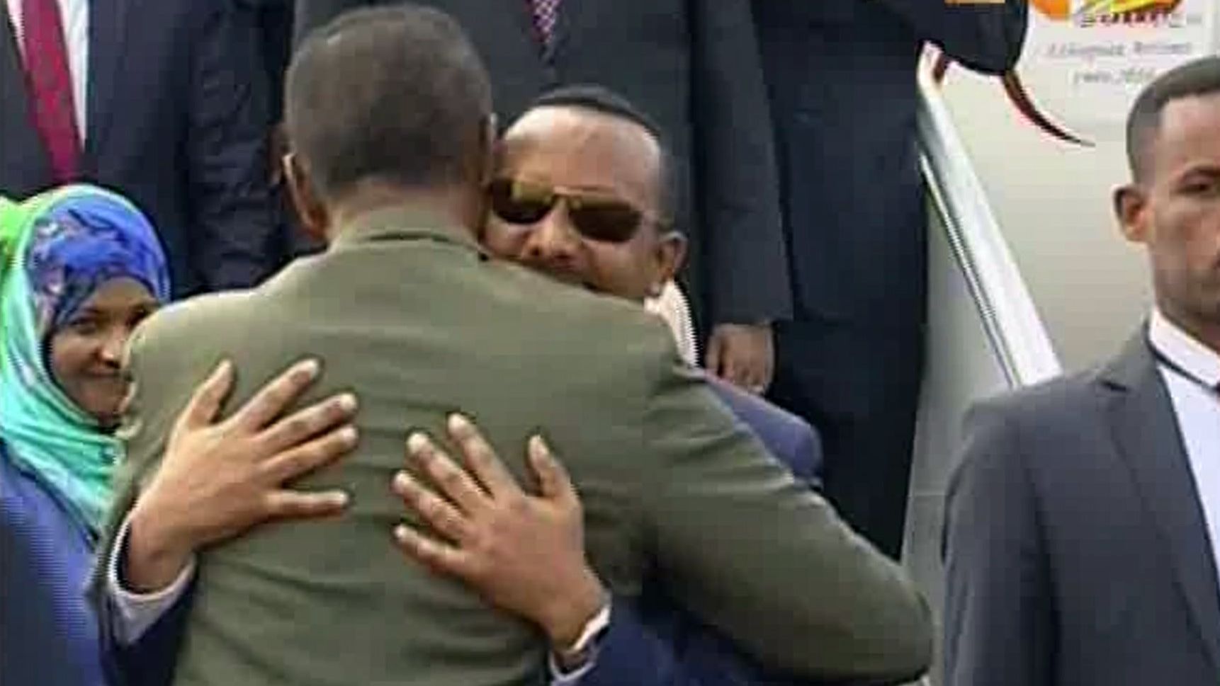 In this grab taken from video provided by ERITV, Ethiopia's Prime Minister Abiy Ahmed, background centre is welcomed by Eritrea's President Isaias Afwerki as he disembarks the plane, in Asmara, Eritrea, Sunday, July 8, 2018.

