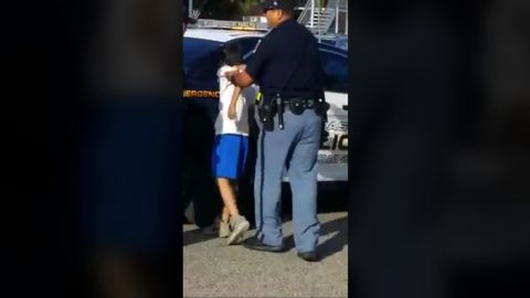 A boy is held against an El Paso police car. 