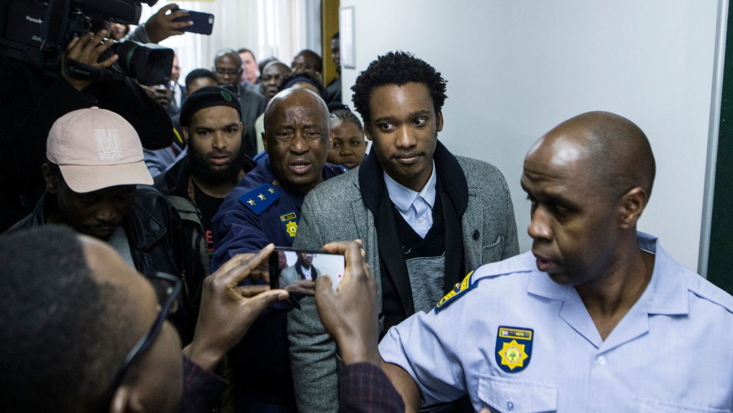 Duduzane Zuma (2R), son of former South African president Jacob Zuma, leaves a Johannesburg court, where he faced corruption charges before being released on bail on July 9, 2018. 