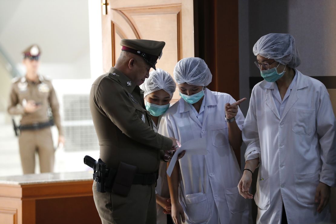 Thai hospital staff and a police officer at Chiang Rai Prachanukroh Hospital on Tuesday. 
