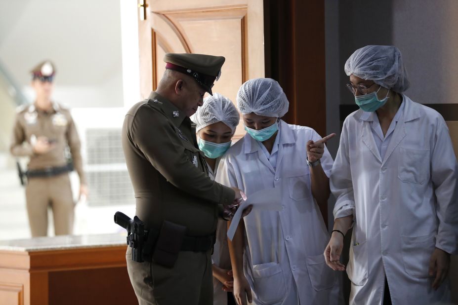 Hospital staff and a police officer are seen during a news conference that was held on July 10. The eight boys that had been rescued on July 8 and 9 were being treated in an isolation ward in a Chiang Rai hospital.