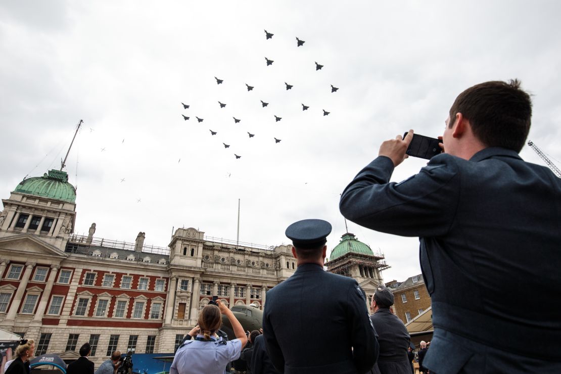 Members of the Royal Air Force watch Typhoon FGR4 aircraft fly over Horse Guards Parade.