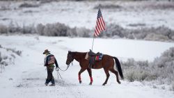 FILE - In this Jan. 7, 2016, file photo, cowboy Dwane Ehmer, of Irrigon, Ore., a supporter of the group occupying the Malheur National Wildlife Refuge, walks his horse near Burns, Ore. The last named defendant in the armed occupation of an Oregon wildlife refuge, not seen, was still at large Tuesday, March 22, 2016, drawing calls for supporters to flock to his Montana hometown and a local sheriff to urge outsiders to stay of it. (AP Photo/Rick Bowmer, File)
