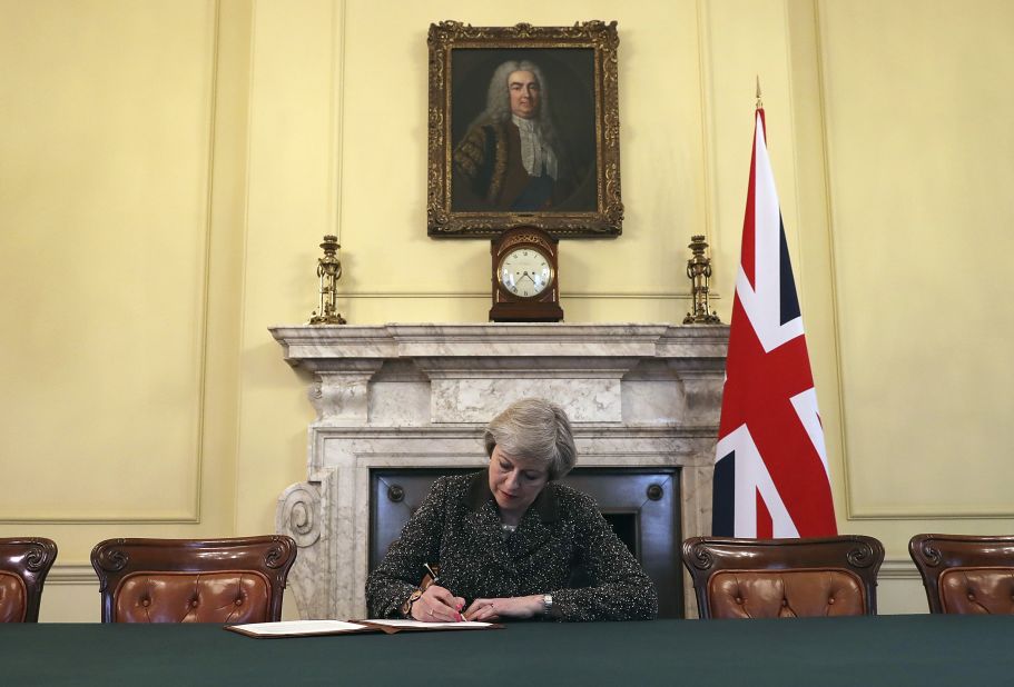 May signs a letter to European Council President Donald Tusk in March 2017 to start the formal process of Britain leaving the EU. She is sitting beneath a portrait of Robert Walpole, generally regarded as Britain's first Prime Minister.