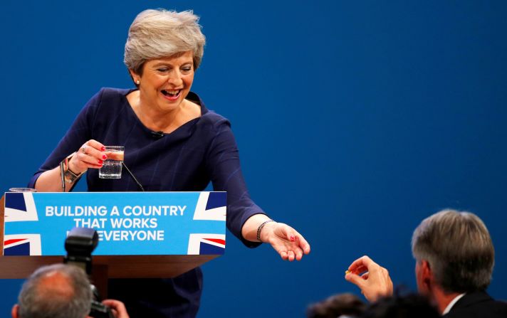 May receives a cough drop from UK finance minister Philip Hammond while having a coughing fit in an address to a Conservative Party conference in Manchester in October 2017. Earlier in the speech, she was<a href="index.php?page=&url=https%3A%2F%2Fwww.cnn.com%2F2017%2F10%2F04%2Feurope%2Ftheresa-may-speech-disaster-conservative-party-conference%2Findex.html" target="_blank"> interrupted by a prankster,</a> who handed her a P45 form. A P45 is given to UK employees when they leave a company, similar to a pink slip in the United States.