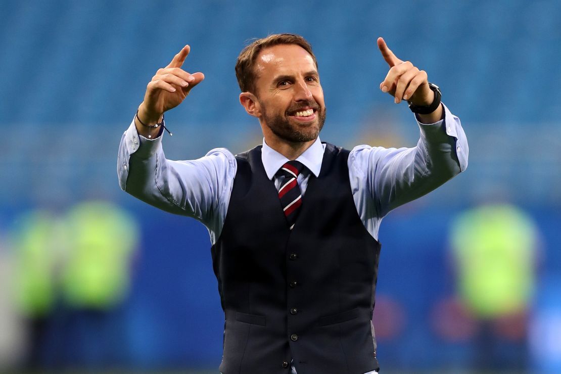 Gareth Southgate conducts the crowd as they sing a song to him.