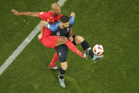 Giroud is challenged by Belgium defender Vincent Kompany.
