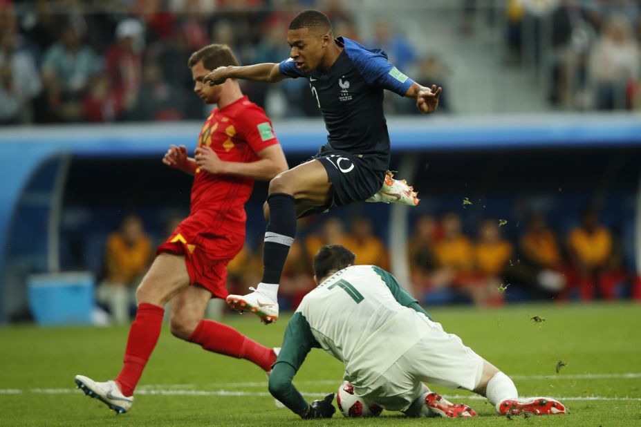 France's teenage sensation, Kylian Mbappe, jumps over Belgian goalkeeper Thibaut Courtois.