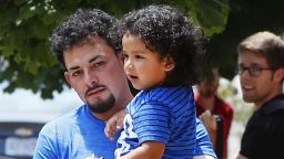 Ever Reyes Mejia, of Honduras, carries his son to a vehicle after being reunited and released by United States Immigration and Customs Enforcement in Grand Rapids, Mich., Tuesday, July 10, 2018. Two boys and a girl who had been in temporary foster care in Grand Rapids, were reunited with their Honduran fathers after they were separated at the U.S.-Mexico border about three months ago. (AP Photo/Paul Sancya)